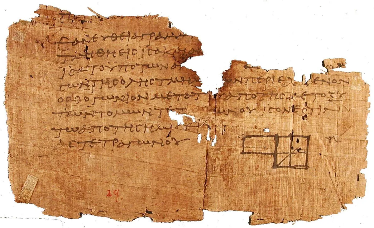 A torn brown papyrus in two joined pieces, carrying about eight lines of Greek in dark ink, with a small drawn rectangle divided by lines at the lower right.