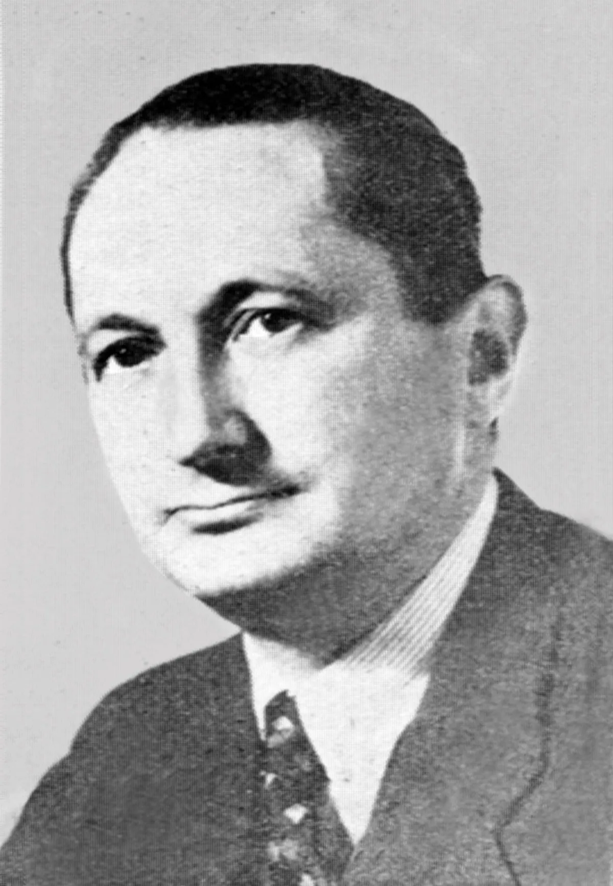 A black and white photographic portrait of an older man, head and shoulders, reproduced on a printed page.