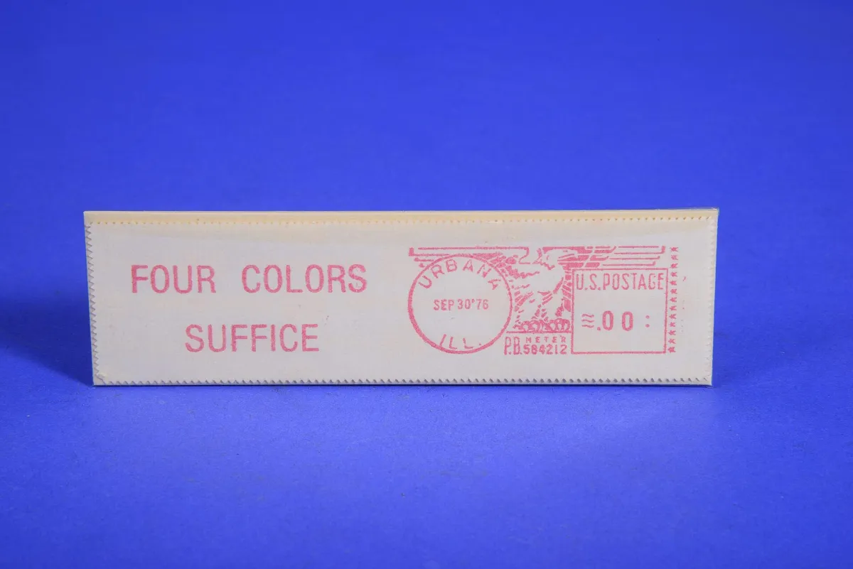 A postal meter impression printed in red on a small cream strip standing against a blue background, reading FOUR COLORS SUFFICE beside a circular URBANA ILL. postmark dated SEP 30 '76.