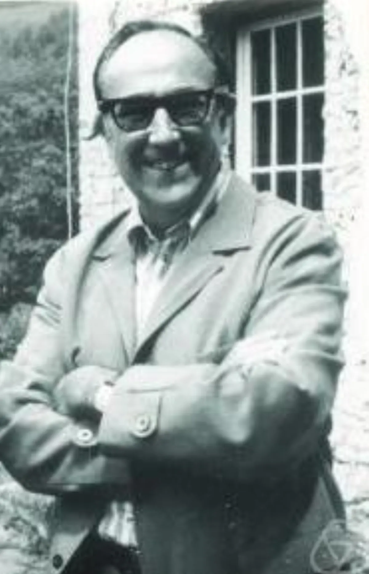 A standing portrait of Klaus Wagner with his arms crossed, wearing dark sunglasses.